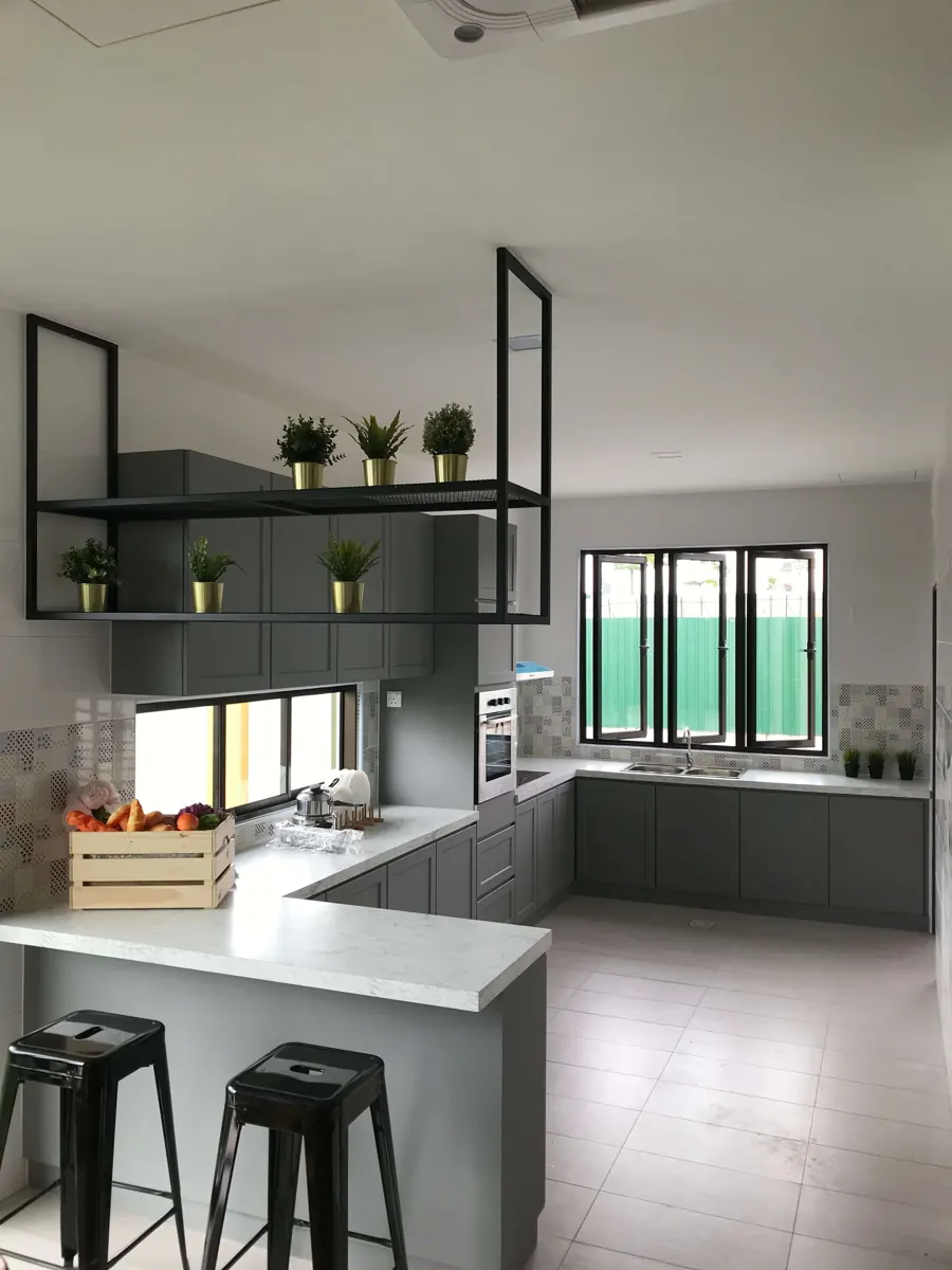U-shaped kitchen with grey cabinets, white worktop, a breakfast counter with two black stools and a hanging metal shelf