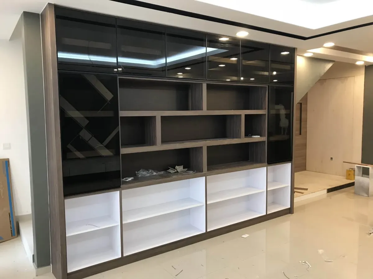Full-wall built-in cabinet with smoked glass upper doors, dark wood open shelves and white lower shelving