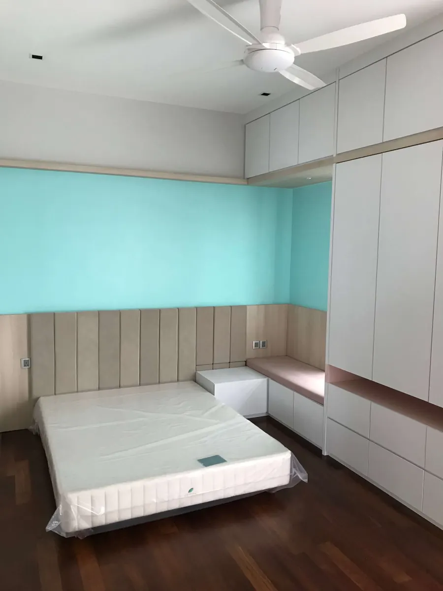 儿童房里的白色入墙衣柜和顶柜，旁边有长条坐凳和软包床头墙