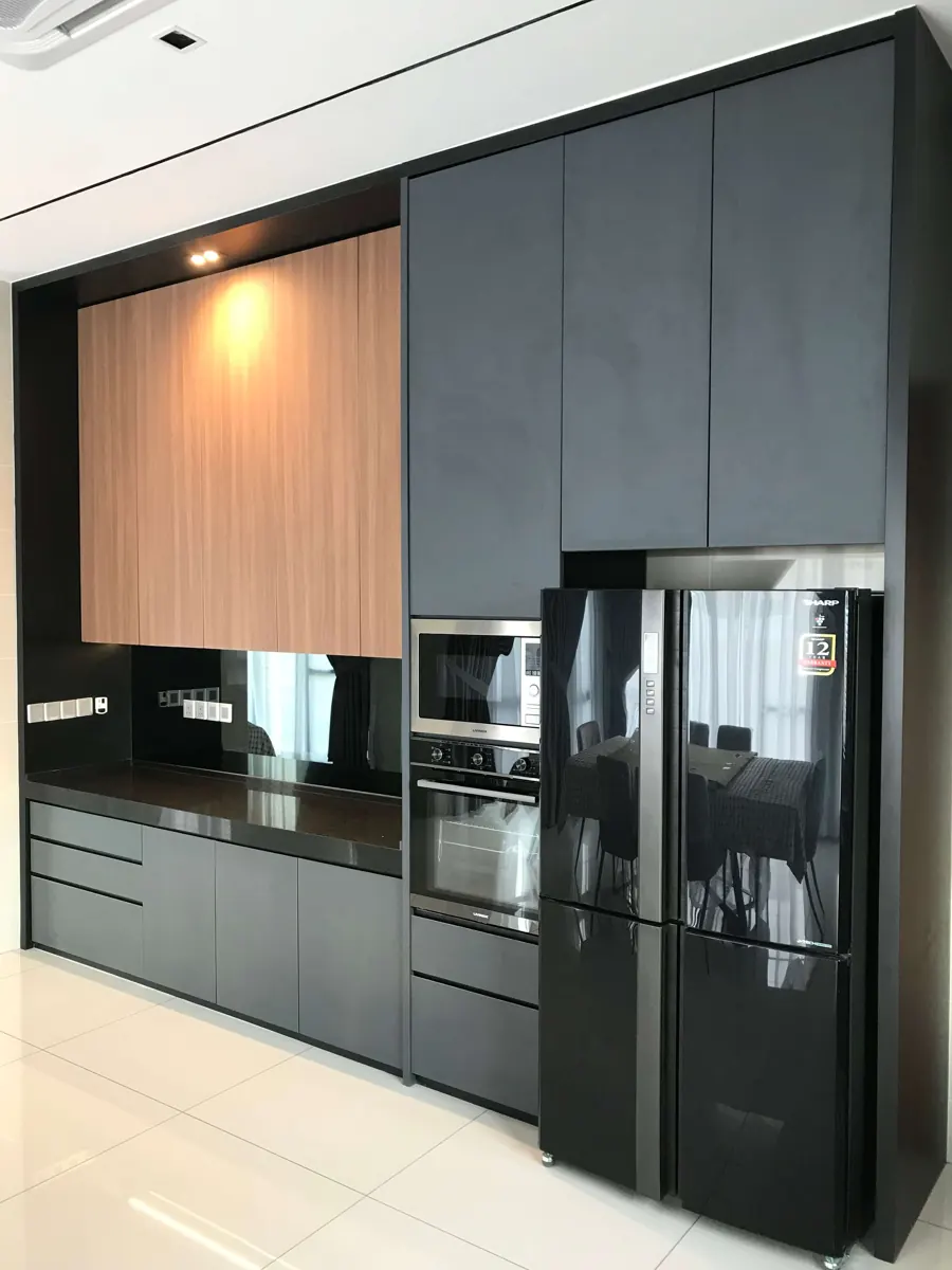 Dark grey tall kitchen cabinets with a wood-grain upper section, built-in oven and fridge recess