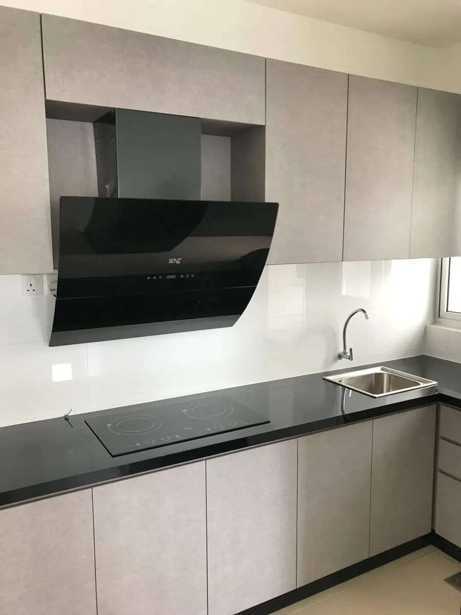 Wet kitchen run with grey cabinets, slanted black cooker hood, induction hob, black worktop and a single steel sink