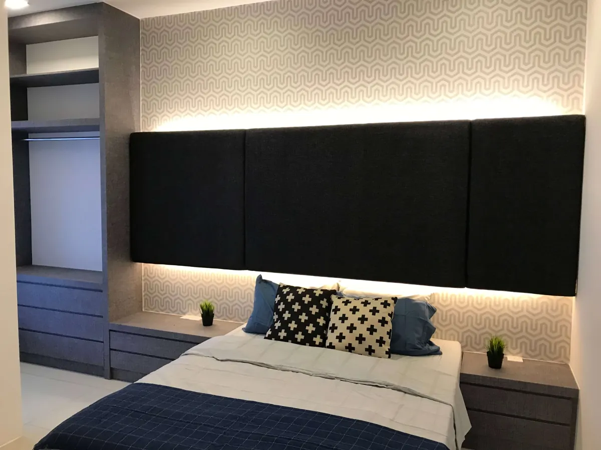 Bilik tidur dengan panel kepala katil berlapik gelap, lampu tersembunyi, almari terbuka built-in dan laci sisi katil